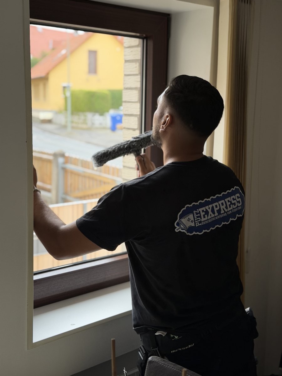 Fensterreinigung Göttingen: Putzexpress-Mitarbeiter reinigt eine Glasfront mit Einwascher