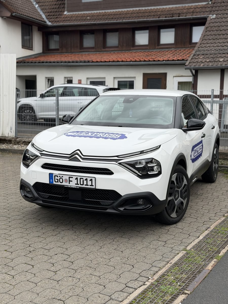 Putzexpress-Firmenwagen mit Göttinger Kennzeichen vor einem Mehrfamilienhaus